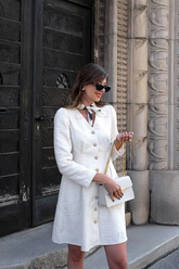 a lady wears a white tweed mini dress with v-neck design